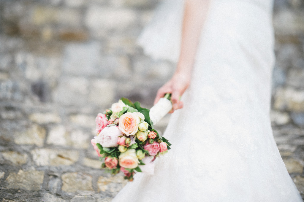 54_Hochzeitsreportage_Wuerzburg_Portrait_Brautstrauss_Residenz_Steinwand_Freelensing